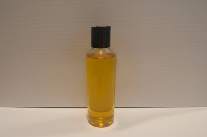 Clear bottle with yellow liquid and black cap on a white background